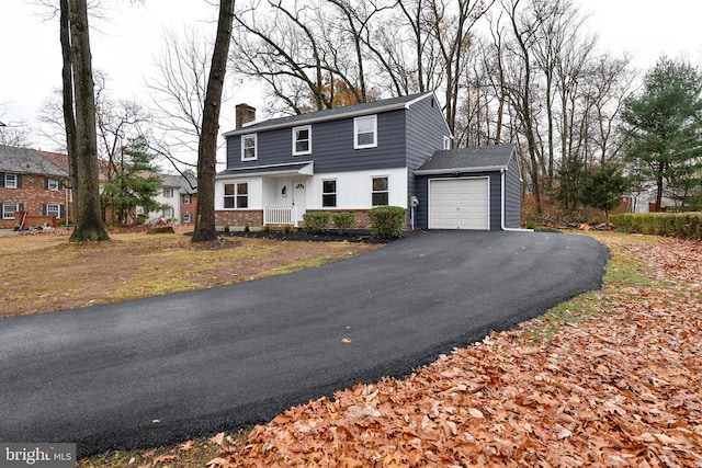 view of property featuring covered porch and a garage