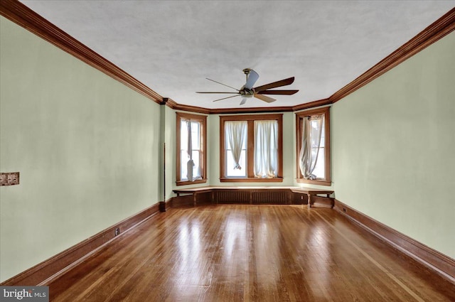 unfurnished room with hardwood / wood-style floors, crown molding, and ceiling fan