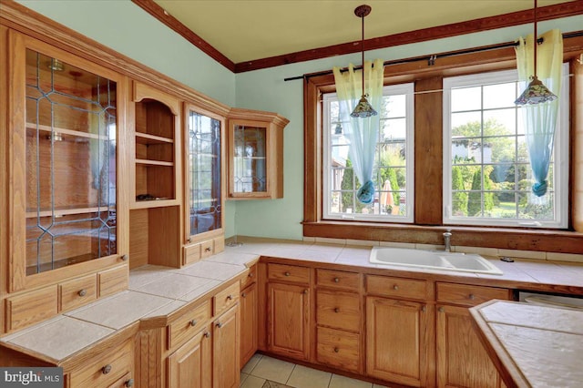 kitchen featuring sink, decorative light fixtures, tile counters, and light tile patterned floors