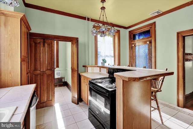 kitchen featuring tile countertops, a kitchen bar, pendant lighting, and black electric range