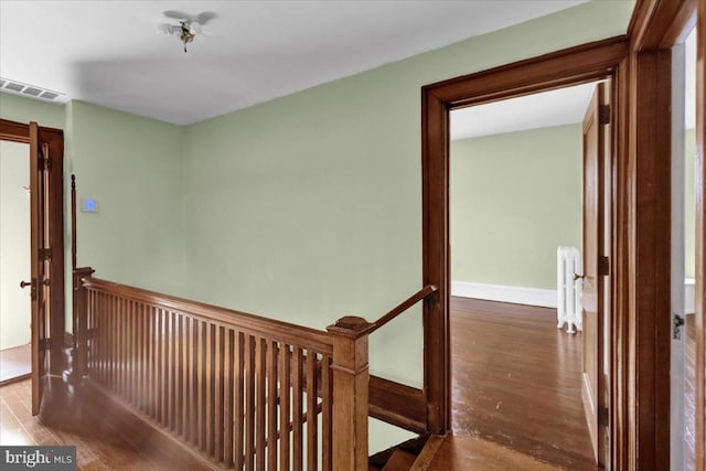 hallway featuring radiator heating unit and hardwood / wood-style floors