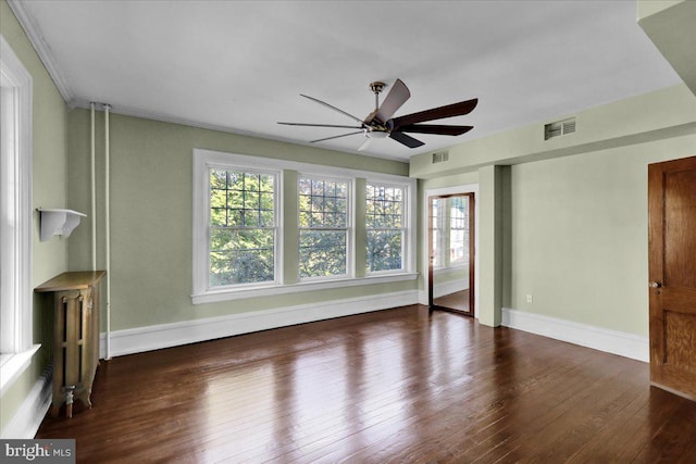 unfurnished living room featuring dark hardwood / wood-style floors, radiator heating unit, and ceiling fan