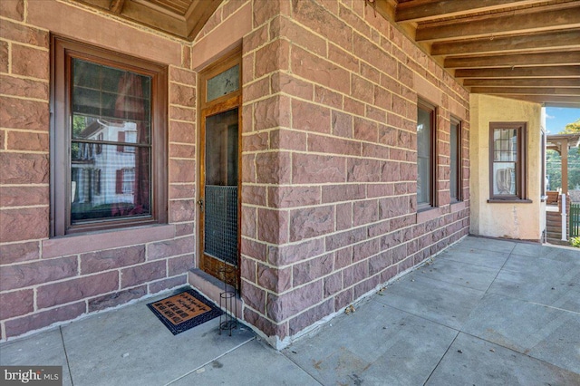 view of exterior entry featuring a patio area