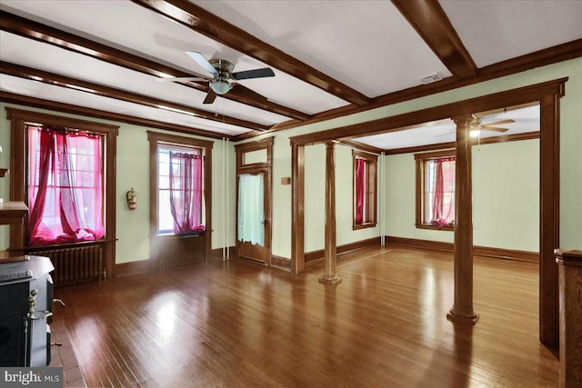 unfurnished living room featuring hardwood / wood-style flooring, beamed ceiling, decorative columns, crown molding, and radiator heating unit