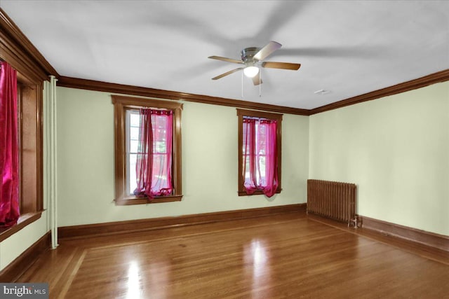 spare room with ceiling fan, hardwood / wood-style flooring, ornamental molding, and radiator heating unit