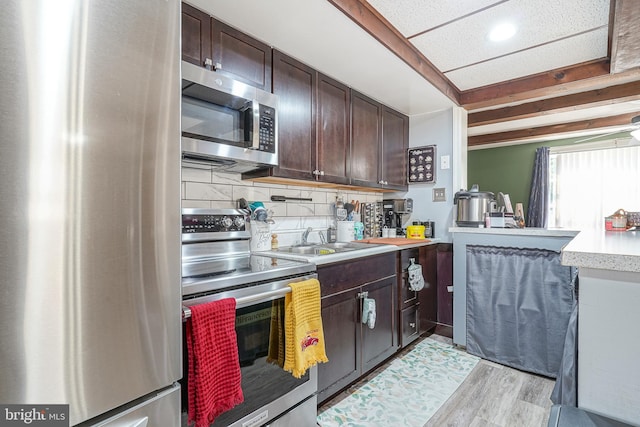 kitchen with sink, decorative backsplash, light hardwood / wood-style floors, dark brown cabinetry, and stainless steel appliances