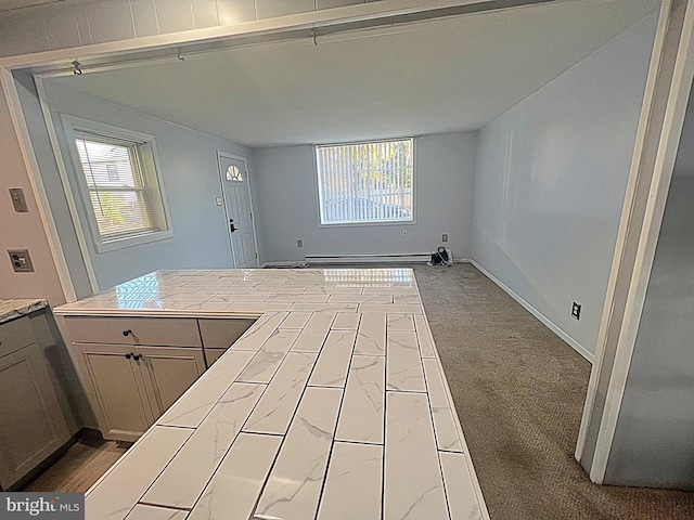 kitchen featuring baseboard heating and light colored carpet