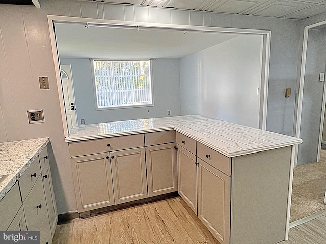 kitchen featuring kitchen peninsula and light hardwood / wood-style floors