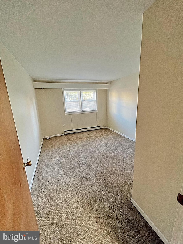 carpeted spare room featuring a textured ceiling and a baseboard heating unit