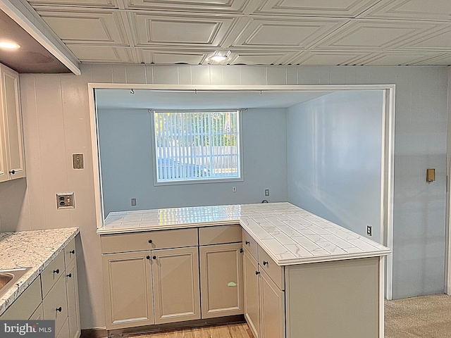 kitchen with light hardwood / wood-style flooring and tile counters