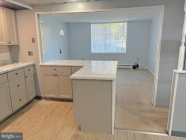 kitchen with decorative backsplash, light wood-type flooring, gray cabinetry, baseboard heating, and tile countertops