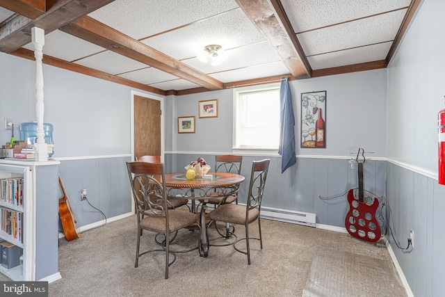 dining space featuring beamed ceiling, carpet floors, baseboard heating, and wood walls