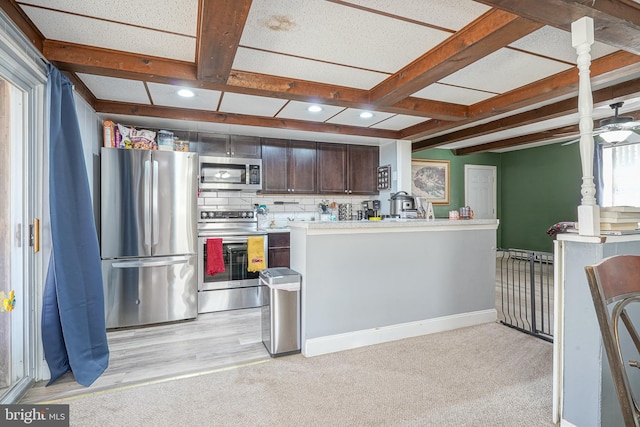 kitchen with light carpet, backsplash, dark brown cabinetry, stainless steel appliances, and beam ceiling