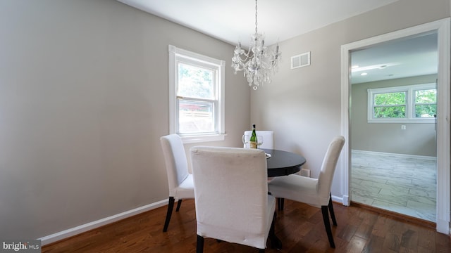 dining area featuring a notable chandelier, plenty of natural light, and dark hardwood / wood-style floors