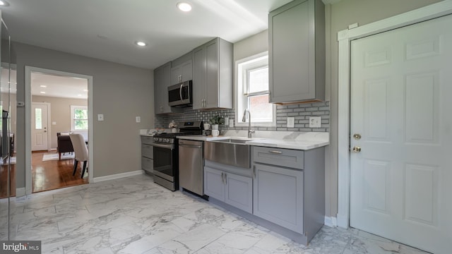 kitchen with sink, appliances with stainless steel finishes, a wealth of natural light, and decorative backsplash