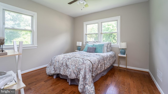 bedroom featuring multiple windows, ceiling fan, and dark hardwood / wood-style flooring