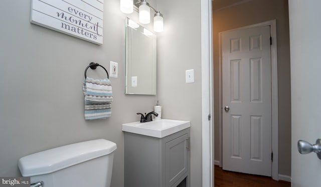 bathroom featuring vanity, hardwood / wood-style flooring, and toilet