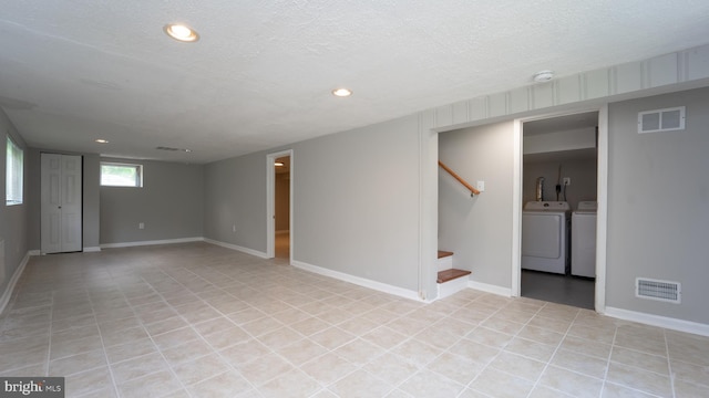 basement featuring a textured ceiling and washer and clothes dryer