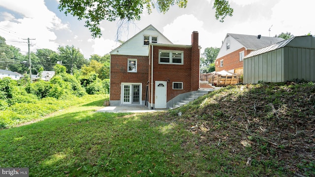 back of house with french doors, a patio area, and a lawn