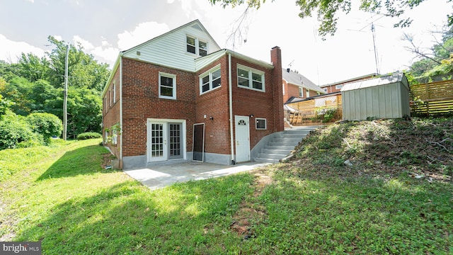 rear view of property featuring a shed, a yard, and a patio