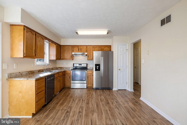 kitchen featuring light hardwood / wood-style flooring, a textured ceiling, sink, and stainless steel appliances