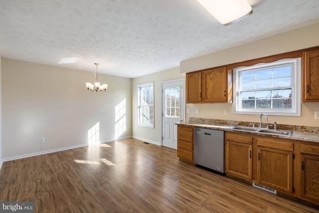 kitchen with dark wood-type flooring, plenty of natural light, decorative light fixtures, and dishwasher