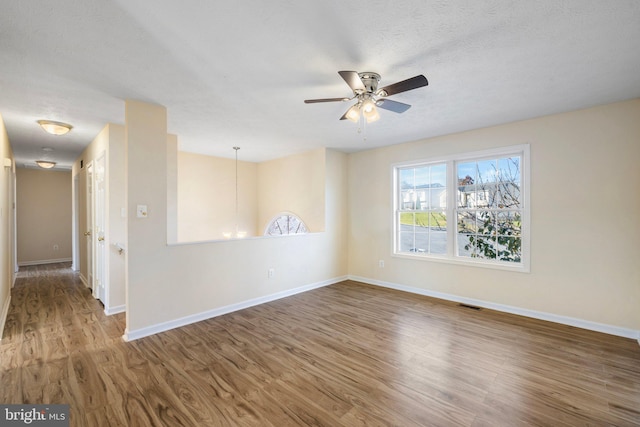 unfurnished room featuring a textured ceiling, hardwood / wood-style floors, and ceiling fan