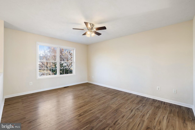 spare room with dark hardwood / wood-style flooring and ceiling fan