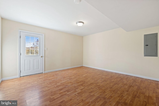 empty room with electric panel and light hardwood / wood-style flooring