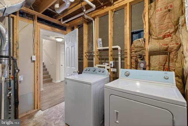 clothes washing area featuring washing machine and dryer and light hardwood / wood-style floors