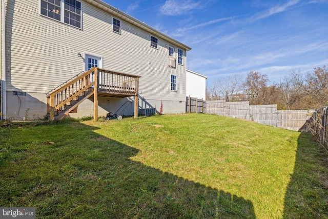 back of house with a deck and a lawn