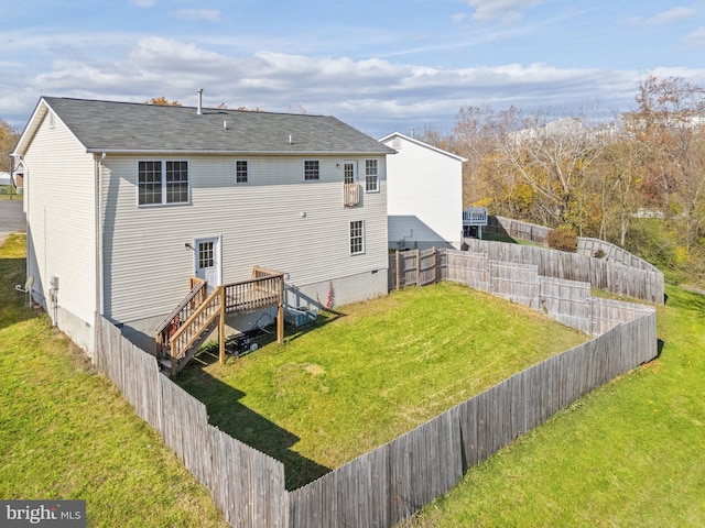 back of house with a deck and a lawn