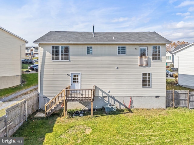 back of house featuring central air condition unit and a lawn