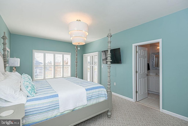 carpeted bedroom with sink and ensuite bath