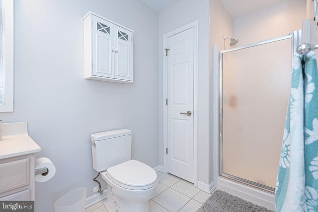 bathroom featuring toilet, vanity, tile patterned floors, and a shower with door