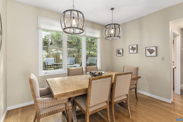 dining space with a notable chandelier and light hardwood / wood-style floors