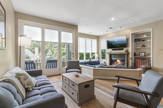 living room featuring built in features and light wood-type flooring