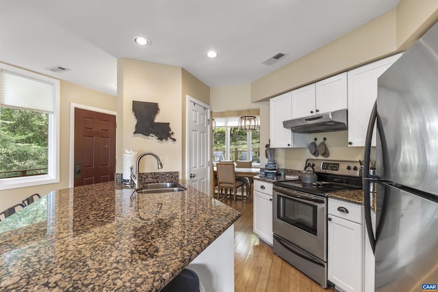 kitchen featuring sink, appliances with stainless steel finishes, white cabinetry, and dark stone counters