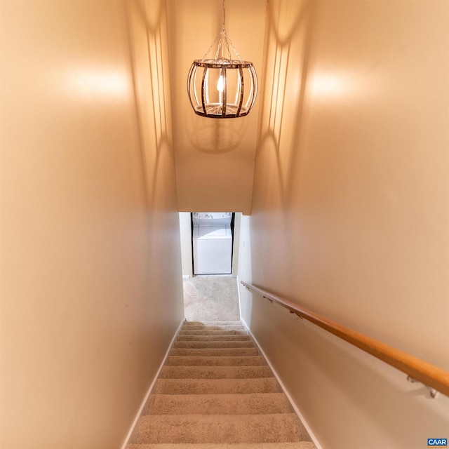 stairway with carpet flooring and a chandelier