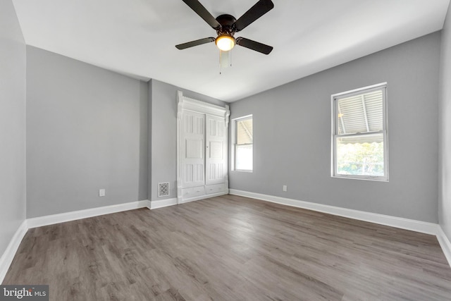 unfurnished bedroom with a closet, hardwood / wood-style flooring, and ceiling fan