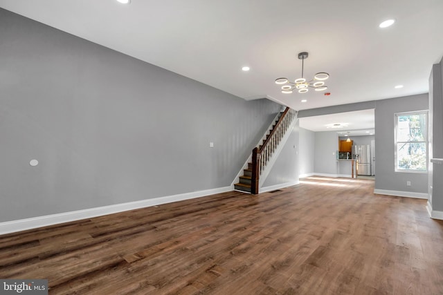 unfurnished living room with hardwood / wood-style flooring and an inviting chandelier