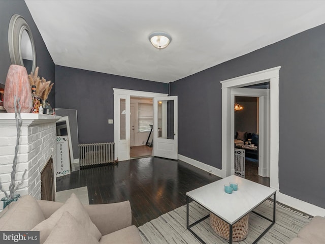 living room featuring hardwood / wood-style flooring and a brick fireplace