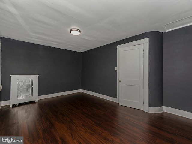 additional living space featuring dark hardwood / wood-style floors and heating unit