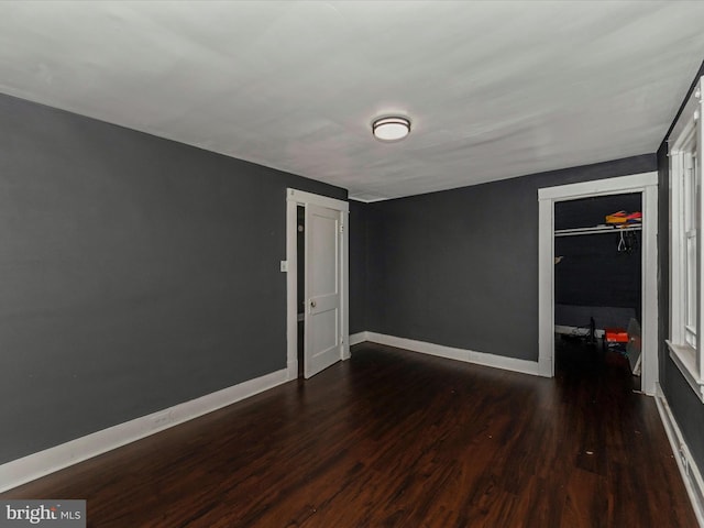 unfurnished bedroom with a closet and dark hardwood / wood-style flooring