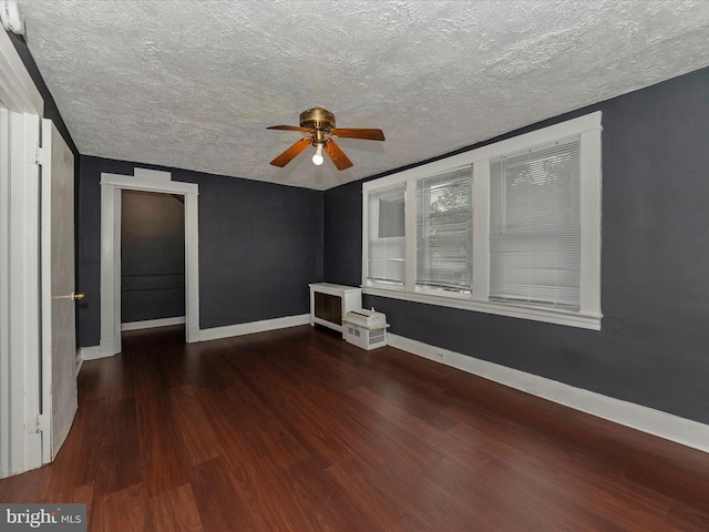 unfurnished room featuring ceiling fan, a textured ceiling, and dark hardwood / wood-style flooring