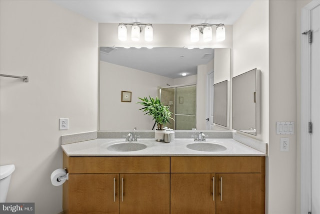 bathroom featuring vanity, toilet, and an enclosed shower