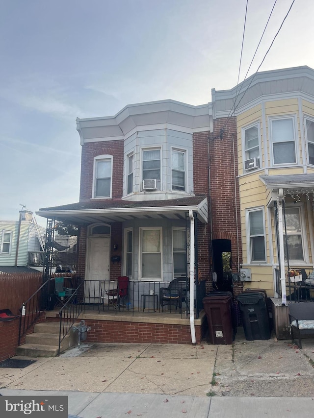 townhome / multi-family property featuring cooling unit and covered porch