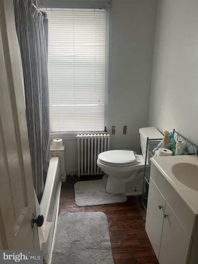 bathroom featuring radiator, toilet, vanity, and hardwood / wood-style flooring