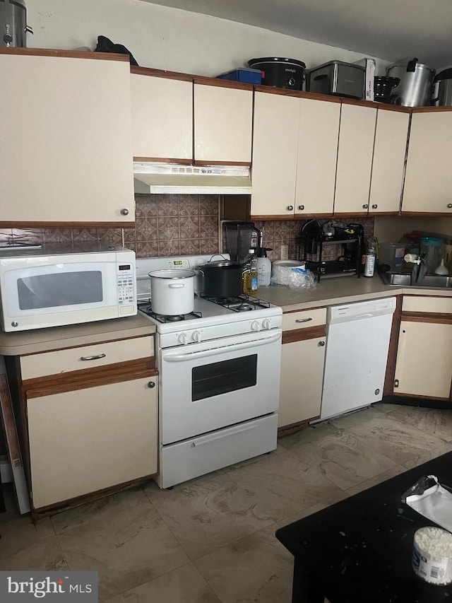 kitchen featuring white cabinets, decorative backsplash, and white appliances