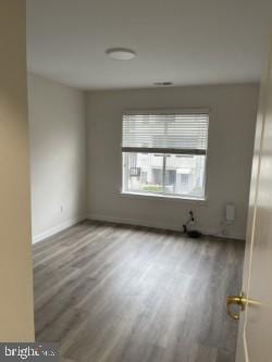 unfurnished room with hardwood / wood-style floors